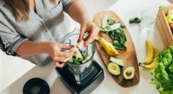 woman making a smoothie with a blender